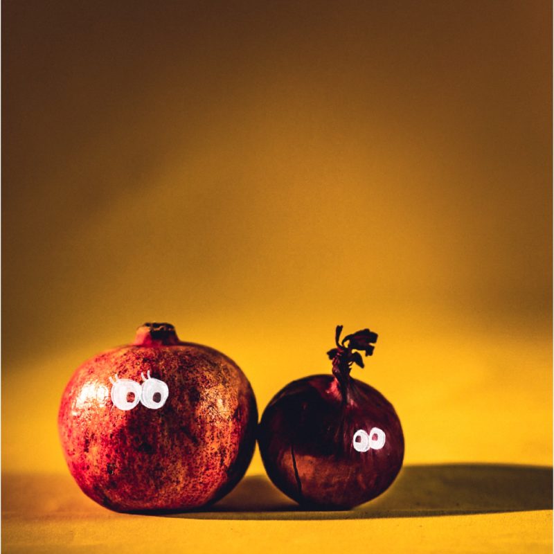Ein Granatapfel & eine Zwiebel mit Augen als Symbol für LGBTIQ+-Hochzeit